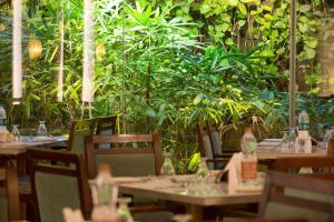 un restaurante con mesas y sillas con plantas en Ramyas Hotels, en Tiruchchirāppalli