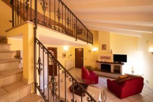 een woonkamer met een trap en rode stoelen bij LA CASA TRA GLI ULIVI in Spello