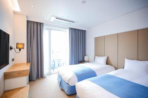 Postel nebo postele na pokoji v ubytování Hotel Whistlelark Jeju