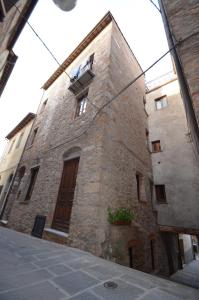 a brick building with a window and a balcony at La Divina Dimora Il Castello degli Spiriti Magni in Montepescali