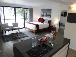 une chambre d'hôtel avec un lit et une cuisine avec un comptoir dans l'établissement Armonik Suites, à Mexico