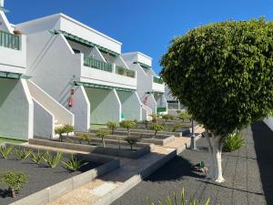 a building with stairs and a tree in front of it at Las Mimosas Beach Sol in Puerto del Carmen