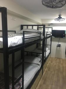 a room with two bunk beds and a wooden floor at Nest Dormitory in Mumbai