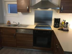 a kitchen with a sink and a stove top oven at Meublé tout confort, avec terrasse in Niederbronn-les-Bains