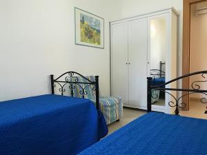 een slaapkamer met 2 bedden en een spiegel bij Casa vacanze laura Otranto centro, Salento 6 posti in Otranto