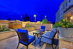 un grupo de sillas y mesas en un patio por la noche en Clarion Hotel The Colony - Plano West en The Colony