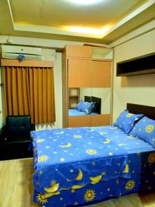 a bedroom with a blue comforter with bananas on it at The suites Metro Apartment by Desta Farispro in Bandung
