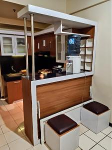 a kitchen with a counter with a sink and a stove at The suites Metro Apartment by Desta Farispro in Bandung