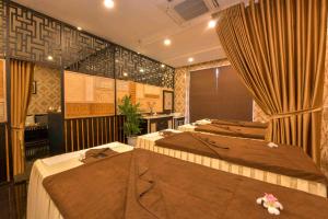 een kamer met 2 bedden en gordijnen bij Fivitel Hoi An Hotel in Hội An