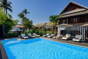 a swimming pool with lounge chairs and a house at Sanctuary Hotel Luang Prabang in Luang Prabang
