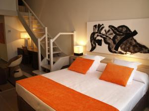 a bedroom with a bed with orange pillows and a staircase at Eco Alcalá Suites in Madrid