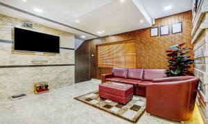 a living room with a couch and a flat screen tv at Treebo Trend Galaxy Suites Mathikere in Bangalore