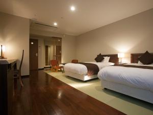 a hotel room with a bed and a dresser at Hotel Nagaragawa No Sato in Gifu