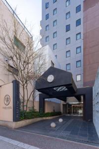 um edifício com um relógio em cima em Plaza Hotel Tenjin em Fukuoka