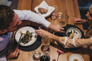 Eine Gruppe von Menschen, die an einem Tisch sitzen und Essen essen. in der Unterkunft Biohotel Rupertus in Leogang