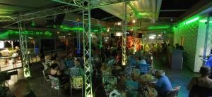 a crowd of people sitting in a room with green lights at Hotel Shipka Beach in Sunny Beach