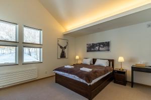 a bedroom with a bed and two windows at Iguru ski chalet with Sauna close to Rusutsu Ski Resort in Rusutsu +24 photos