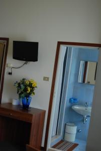 a bathroom with a sink and a vase of flowers at Hotel Tuscolano in Bologna