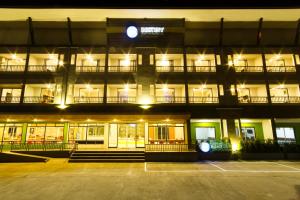 ein großes Gebäude mit einem Parkplatz in der Nacht in der Unterkunft Bestiny Hotel & Restaurant Phetchabun in Ban Na Chaliang