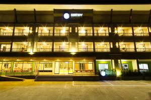 a large building with a parking lot at night at Bestiny Hotel & Restaurant Phetchabun in Ban Na Chaliang