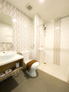 ein Bad mit einem WC, einem Waschbecken und einer Dusche in der Unterkunft Bestiny Hotel & Restaurant Phetchabun in Ban Na Chaliang