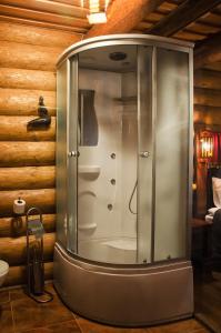 a shower in a bathroom with a wooden wall at Praha Wood House in Uzhhorod