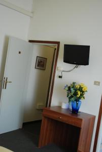 a room with a vase of flowers on a table at Hotel Tuscolano in Bologna