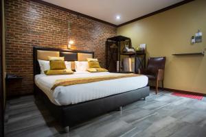 沙美岛Buddies Loft Samet的一间带大床和砖墙的卧室