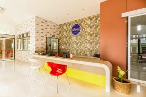 ein Restaurant mit einer Theke und roten Stühlen in einem Zimmer in der Unterkunft Bestiny Hotel & Restaurant Phetchabun in Ban Na Chaliang