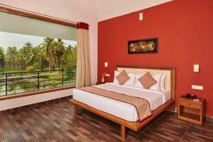 a bedroom with a large bed and a large window at Sterling Palavelli Godavari in Rāzole