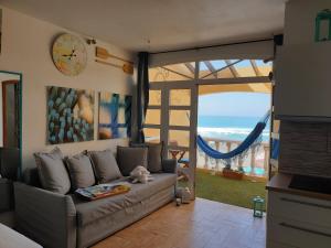 sala de estar con sofá y vistas al océano en Ajuy Tortuga House, en Ajuy