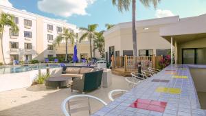 eine Terrasse mit einem Tisch und Stühlen neben einem Pool in der Unterkunft Holiday Inn - Fort Myers - Downtown Area, an IHG Hotel in Fort Myers