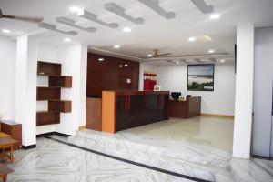 an office lobby with a reception desk and white walls at Hotel Adarsh in Aurangabad