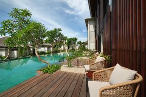 an outdoor deck with chairs and a swimming pool at The Garcia Ubud Hotel & Resort in Ubud