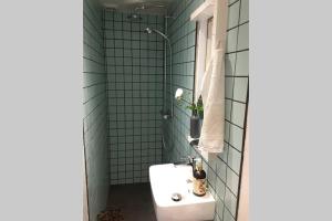 baño con lavabo blanco y azulejos verdes en Central Apartment in attractive Østerbro, en Copenhague
