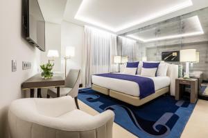a hotel room with a bed and a desk and a chair at Room Mate Collection Filippo, Rome-Fontana di Trevi in Rome