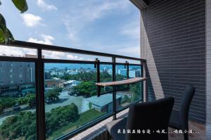 einen Balkon mit einem Stuhl und Stadtblick in der Unterkunft Mambo Boutique Hotel in Altstadt von Hengchun