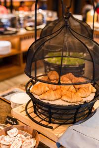 a basket of croissants and pastries on a table at Aurico Kata Resort & Spa - SHA Extra Plus in Kata Beach
