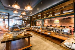a restaurant with people sitting at tables in a cafeteria at Aurico Kata Resort & Spa - SHA Extra Plus in Kata Beach