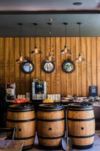 a bar with three wooden barrels in a restaurant at Aurico Kata Resort & Spa - SHA Extra Plus in Kata Beach