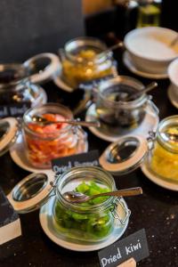 a table with plates of food and jars of pickles at Aurico Kata Resort & Spa - SHA Extra Plus in Kata Beach