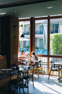 a group of people sitting at a table in a restaurant at Aurico Kata Resort & Spa - SHA Extra Plus in Kata Beach