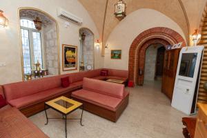 a living room with a red couch in a building at Azzahra Boutique Hotel & Restaurant - Jerusalem in Jerusalem