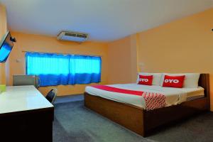 um quarto de hotel com uma cama com duas almofadas vermelhas em OYO 588 Rose In Mansion em Trang