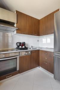 a kitchen with wooden cabinets and stainless steel appliances at Melon Suites in Thessaloniki