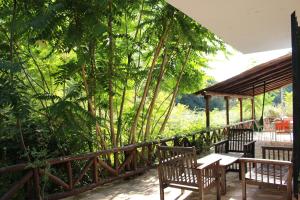 Un patio con bancos y una mesa y árboles. en La Cobacha, en Cazalla de la Sierra