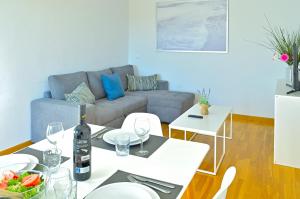 Una sala de estar con un sofá y una mesa con copas de vino. en Stay In Brisas del Sur, en Alicante