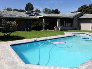 a swimming pool in front of a house at 8 Ibis Lane Guest House in Johannesburg