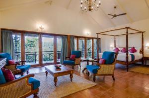 a bedroom with a bed and chairs and a table at Pepper Trail in Sultan Bathery