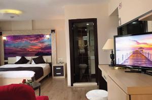 a hotel room with a bed and a flat screen tv at Rumana Hotel in Anamur